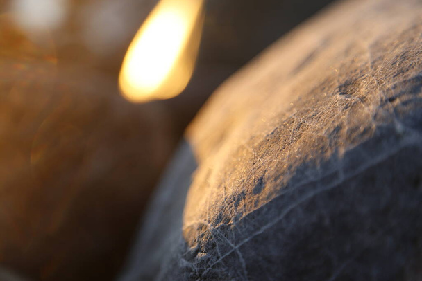Kamenitá pláž kameny a skály zalité sluncem v podvečer detailní záběr, textura západ slunce a východ slunce - Fotografie, Obrázek