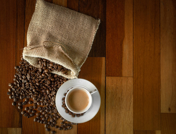 Kaffee auf Holztisch mit Kaffeebohnen im Beutel. - Foto, Bild