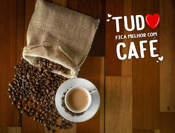 Koffie op houten tafel met koffiebonen in zak. Tekst: Alles is beter met koffie. - Foto, afbeelding