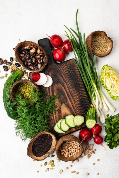 Tabla de cortar de madera con verduras frescas, ingredientes para cocinar comida vegana. Vista superior
 - Foto, Imagen