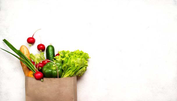 Bolsa de papel llena de diferentes productos alimenticios saludables. Vista superior con lugar para texto
. - Foto, Imagen
