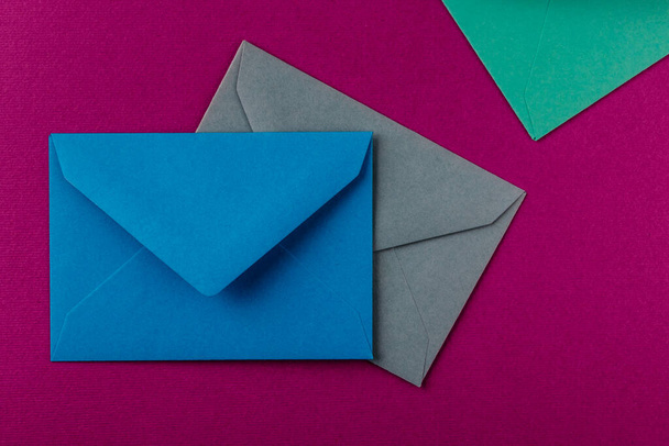 Envelopes coloridos sobre um fundo roxo. Envelopes de correio na mesa
. - Foto, Imagem