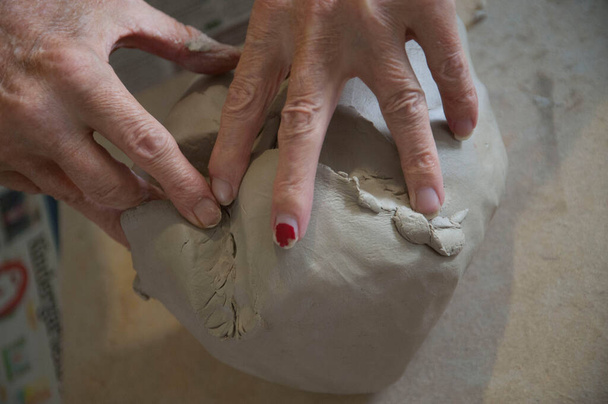 una mano che tocca una palla di argilla, la percezione tattile e aptica umana - Foto, immagini