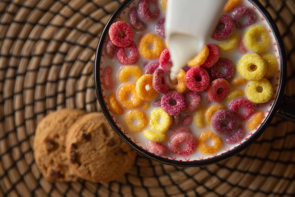 Foto della colazione con cappi colorati cereali, biscotti e latte. - Foto, immagini