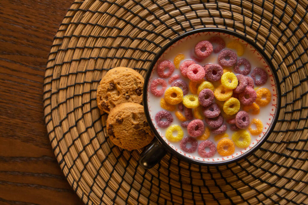 Snídaňové fotografie se smyčkami barevné cereálie, sušenky a mléko. - Fotografie, Obrázek