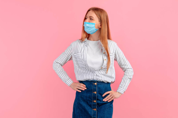 young woman in a medical protective mask on her face, on an isolated pink background. Coronavirus epidemic, quarantine, virus protection - Foto, immagini