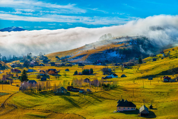 Сельский пейзаж с туманом в деревне Сирнеа Фундата, достопримечательность Трансильвании, Румыния
 - Фото, изображение