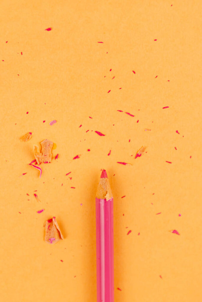 pink pencil and shavings on orange paper background - Φωτογραφία, εικόνα