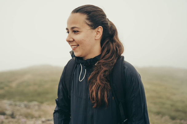 Hiker smiling on top of the mountain in the middle of nature on a cloudy day. - Zdjęcie, obraz