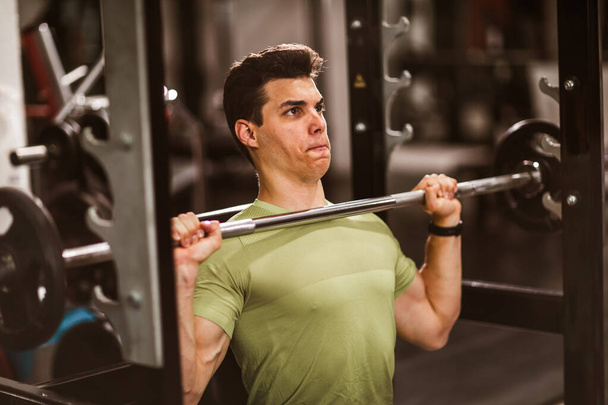 Jeune homme beau faire des exercices dans la salle de gym - Photo, image