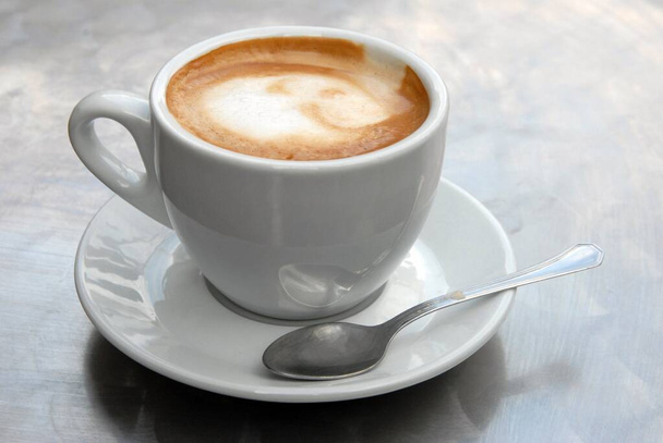 Чашка кофе в блюдце с ложкой крупным планом
  - Фото, изображение