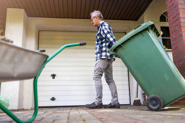 Senior man taking out garbage - Foto, Imagem
