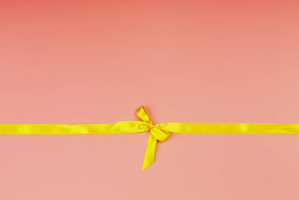 Christmas pink background. Yellow ribbon. - Photo, Image