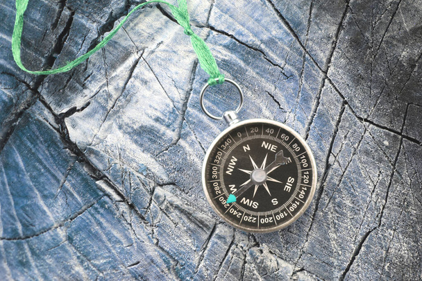 Rundkompass auf blauem Holzgrund als Symbol des Tourismus mit Kompass, Reisen mit Kompass und Outdoor-Aktivitäten mit Kompass - Foto, Bild