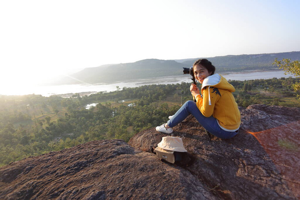 Vrouw zittend en fotograferend bij de klif in Pha Tam National Park, Ubon Ratchathani, Thailand. - Foto, afbeelding