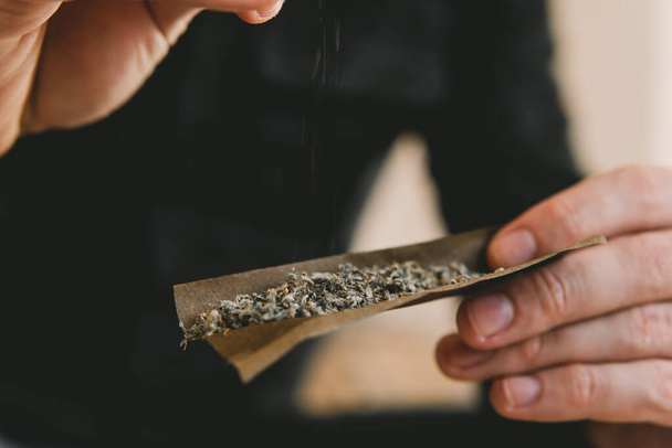Rollen eines Marihuana-Joints. Nahaufnahme von Marihuana stumpf mit Mühle. Vorbereitung und Rollen von Marihuana Cannabis Joint. Cannabis-Nutzungskonzept. - Foto, Bild