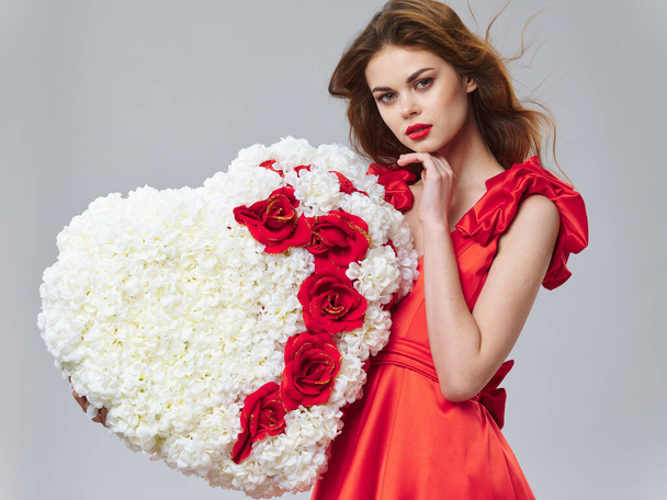 Hart gemaakt van bloemen mooie vrouw rode jurk heldere make-up model  - Foto, afbeelding