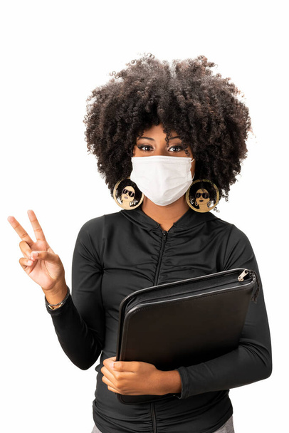 использование медицинской маски в качестве профилактики против ковид-19 коронавируса молодой африканской бразильской красавицы  - Фото, изображение