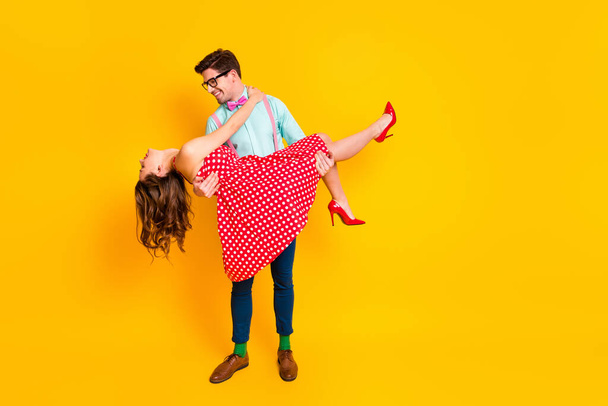 Full body photo of pretty lady handsome guy couple carry lovely girlfriend hands good mood wear red dotted dress shirt bowtie retro clothes isolated yellow bright color background - Foto, Imagen