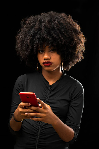 Afro Brazilian girl using a cell phone connected online - Foto, afbeelding
