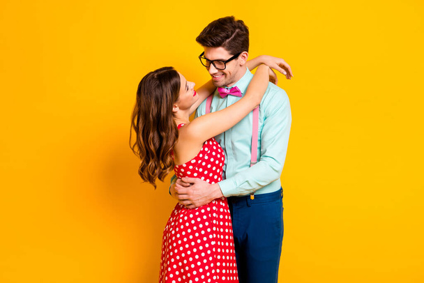 Portrait of positive passionate tender couple girl guy hug embrace cuddle enjoy love wear red dotted dress suspenders shirt pants trousers isolated over bright shine color background - Fotografie, Obrázek