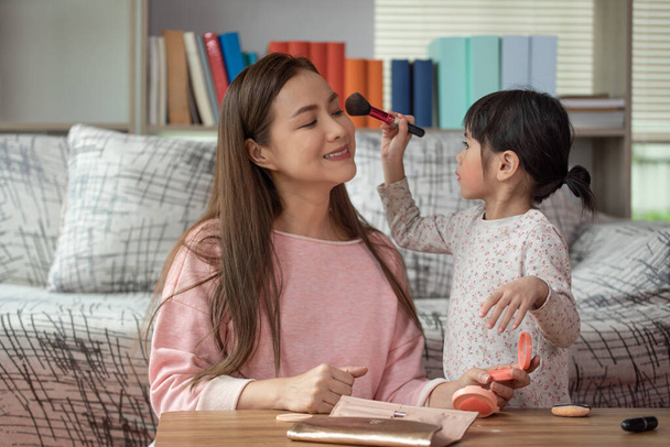 Happy child, Little Asian girl doing makeup with her mother, loving family concept - Фото, изображение