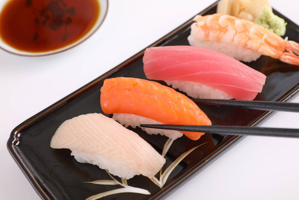 Set de sushi, comida japonesa sushi salmón atún camarones y lubina con palillos aislados en fondo blanco - Foto, Imagen