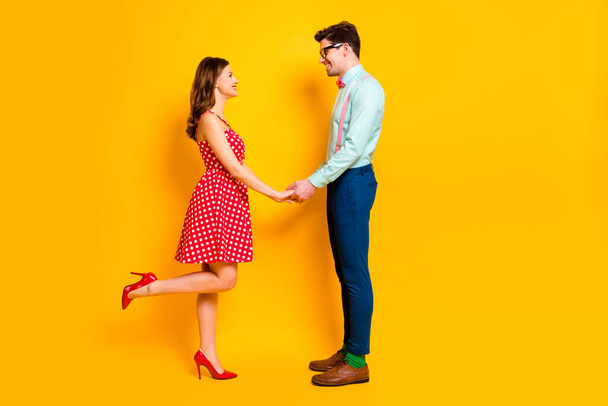 Full size profile photo of pretty lady handsome guy prom party couple photographing hold arms wear red dress shirt bowtie pants elegant outfit isolated yellow bright color background - 写真・画像