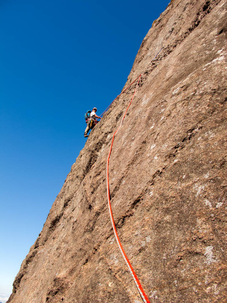 Scalatore di roccia arrampicata su una parete di roccia in pendenza in Brasile - Foto, immagini