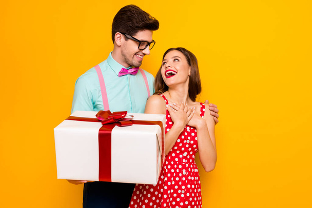 Photo of pretty lady handsome guy couple boyfriend giving girlfriend big gift box 8 march pleasant present wear red dotted dress shirt bowtie pants isolated yellow bright color background - Fotó, kép