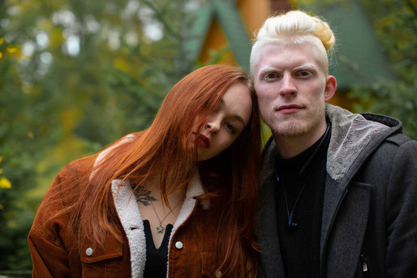 Portrait of a beautiful albino man and a girl with red hair look at the camera - Foto, Imagem