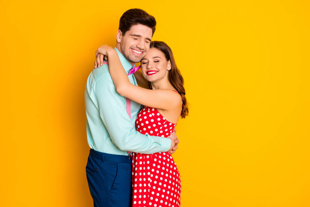 Photo two people attractive lady handsome guy prom party couple hugging posing portrait eyes closed wear red dotted dress shirt bowtie retro clothes isolated yellow color background - Φωτογραφία, εικόνα