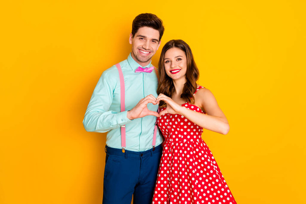 Tender gentle two people couple man woman hug embrace show finger heart shape eternal love sign wear red dotted dress blue shirt pink suspenders isolated bright shine color background - Fotoğraf, Görsel