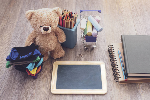 スレートブラックボード、ビンおもちゃの鉛筆、ショッピングカートのチョーク、木製のテーブルの子供のショック、教育の概念 - 写真・画像