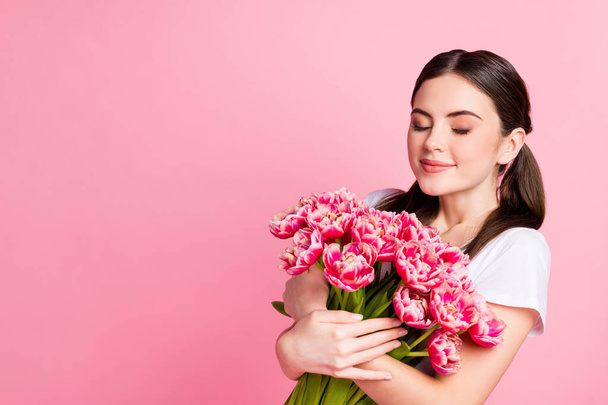 Close-up portrait of her she nice-looking attractive lovely pretty charming dreamy cheery girl holding in hands bunch festal flowers smelling enjoying isolated over pink pastel color background - Фото, зображення