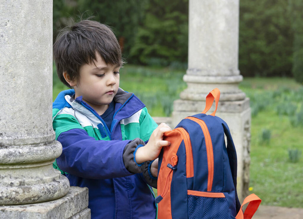 Portrait garçon d'âge préscolaire emballant son sac à dos après l'aventure dans le parc forestier, écolier explorant avec voyage scolaire, les enfants apprenant sur les saisons changent de la nature. - Photo, image