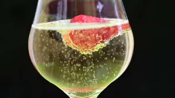 glas met champagne en aardbei op donkere achtergrond, romantisch concept  - Video