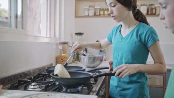 Bambini che preparano frittelle in cucina usando una padella - Filmati, video