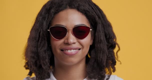 Chica afroamericana positiva levantando gafas y guiñando el ojo
 - Imágenes, Vídeo
