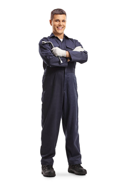 Full length portrait of a mechanic holding a wrench and posing isolated on white background - Foto, afbeelding