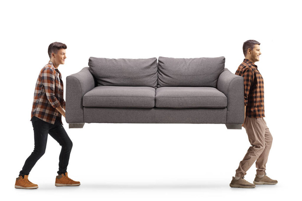 Two guys carrying a gray sofa isolated on white background - Foto, Bild