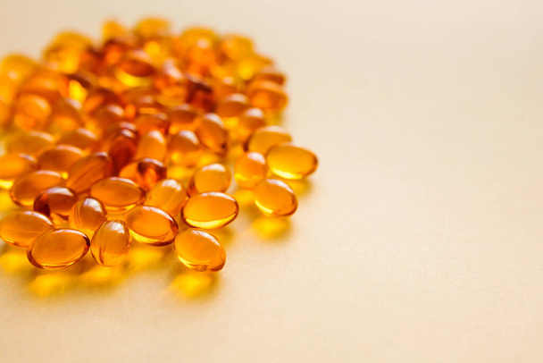 Fischöl-Kapseln auf beigem Hintergrund, Vitamin-D-Quelle, selektiver Fokus. Omega-3. Gesunder Lebensstil. - Foto, Bild