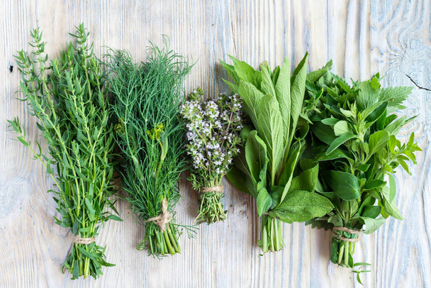 Set of bundles of different fresh green spices herbs on wooden b - Fotó, kép