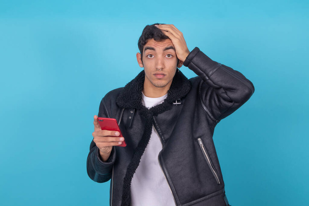 mladý muž s mobilním telefonem izolované na barevném pozadí - Fotografie, Obrázek