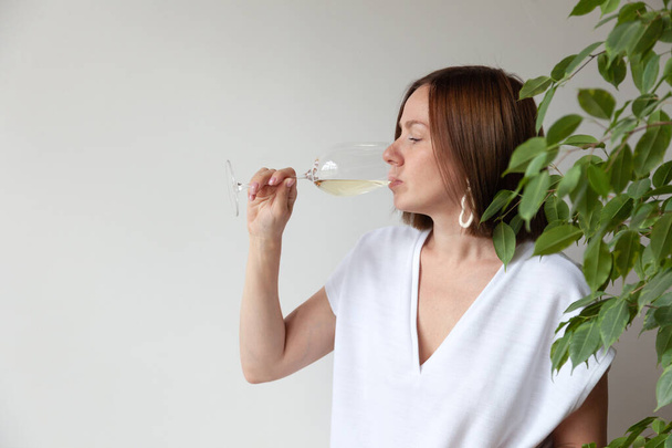 Ragazza bruna caucasica sommelier bere vino bianco da vetro - Foto, immagini