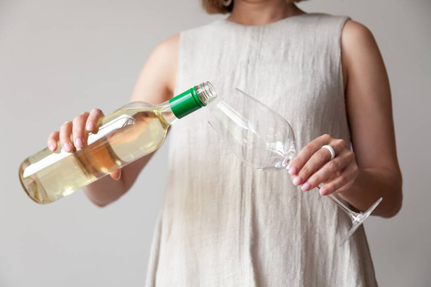 Las manos femeninas vierten vino blanco de la botella al vaso - Foto, Imagen