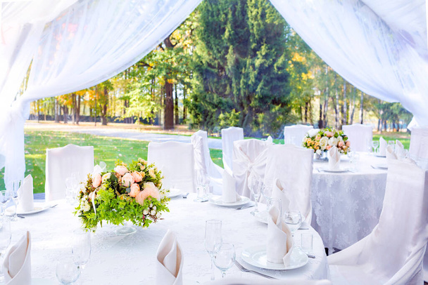 Bruiloft eenvoudige outdoor tafelschikking in een witte buitentent. - Foto, afbeelding