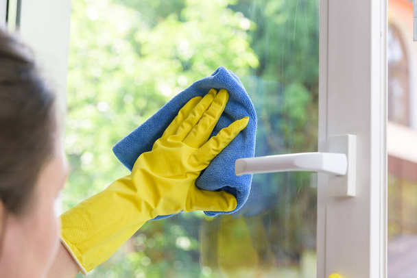Cleaning of opened vinyl window. Protective glove on hand and cleaning cloth - Foto, Bild