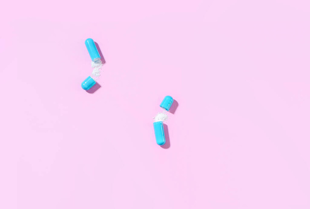 Two blue capsules of white powder medication. View from above - Foto, immagini