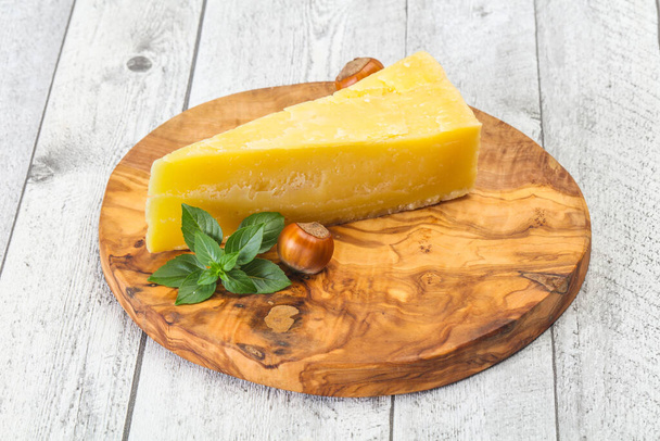 Τυρί παρμεζάνας με φύλλα βασιλικού και ξηρούς καρπούς - Φωτογραφία, εικόνα
